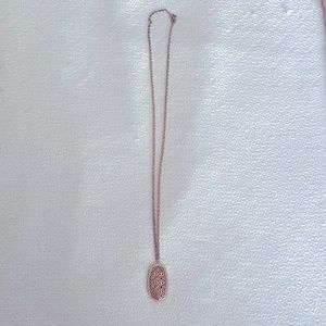 Rose gold Kendra Scott necklace.